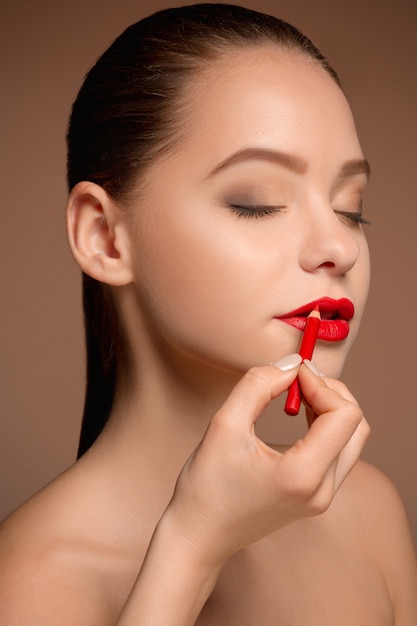 Hermosos labios femeninos con maquillaje y pincel