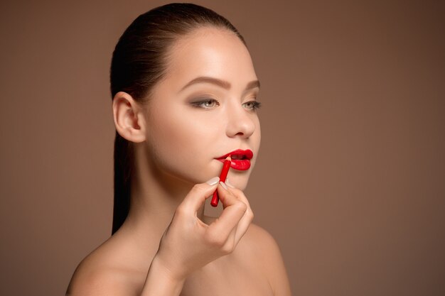 Hermosos labios femeninos con maquillaje y pincel