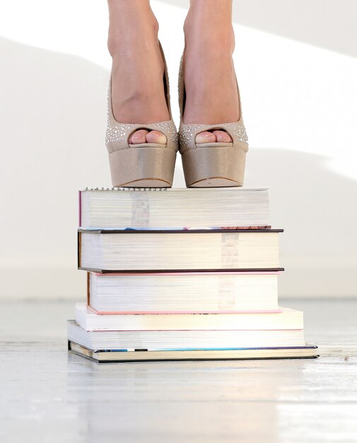 Hermosos pies en libros apilados