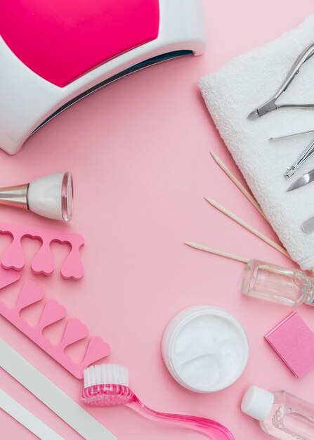 Herramientas de accesorios para el cuidado de las uñas sobre fondo rosa