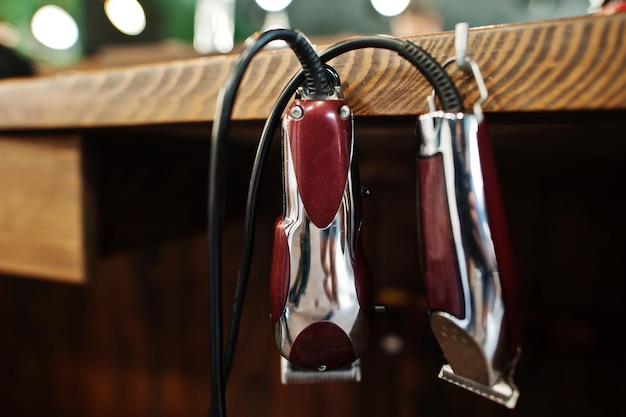 Herramientas de barbero en mesa de fondo de madera con máquinas eléctricas