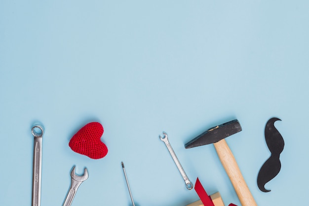 Foto gratuita herramientas con bigote de papel y corazón de juguete.