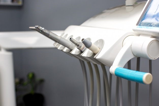 Herramientas dentales con tubos fijados en sillón dental