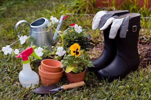 Herramientas de jardinería y flores en el suelo