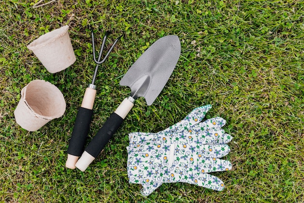 Herramientas de jardinería planas sobre la hierba.