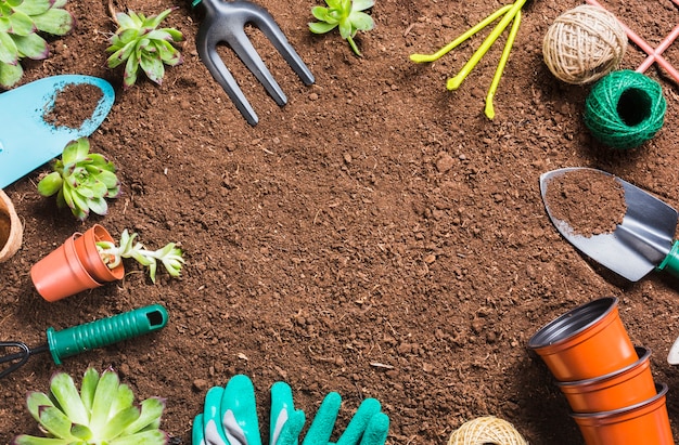 Herramientas de jardinería sobre la tierra vista desde arriba