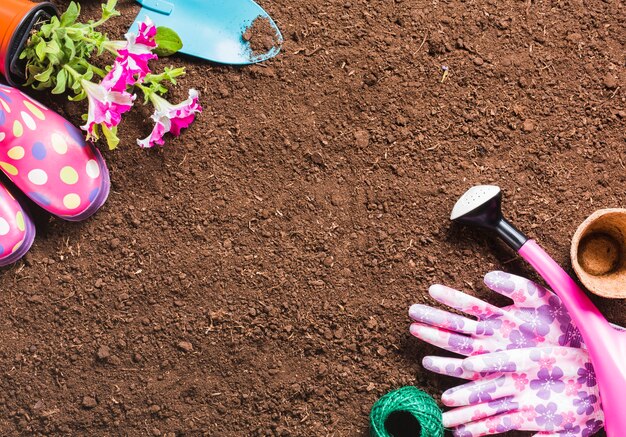 Herramientas de jardinería sobre la tierra vista desde arriba