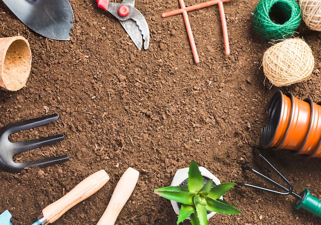 Foto gratuita herramientas de jardinería sobre la tierra vista desde arriba