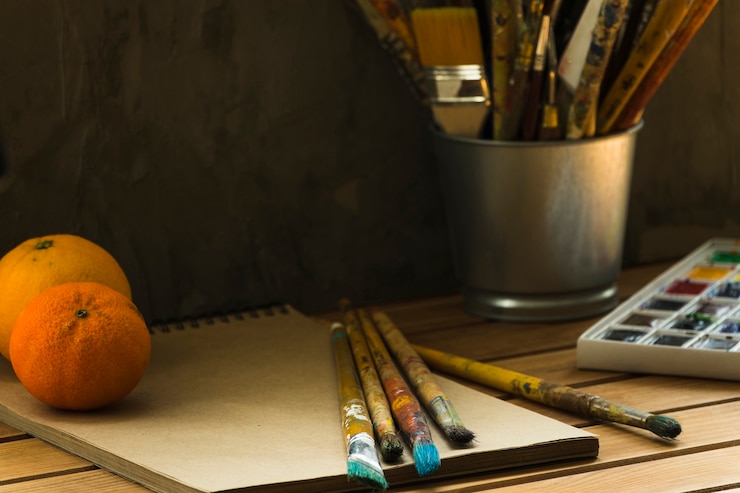 Foto gratuito herramientas de pintor y naranjas en una mesa