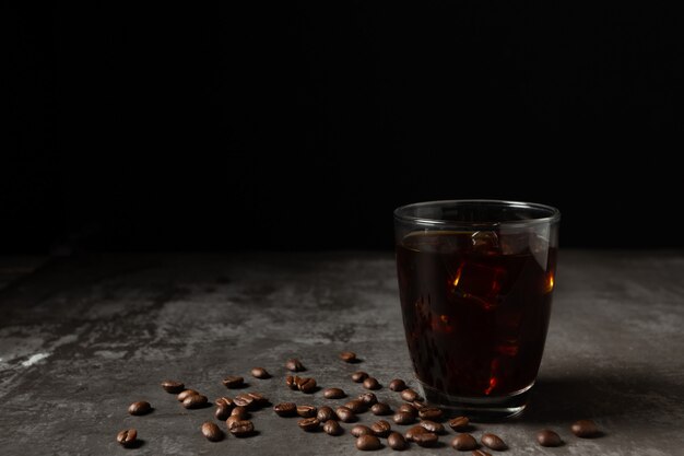 Hiele el café sólo en un vidrio en la tabla de madera.