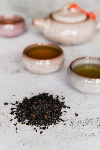 Foto gratuita hierbas secas con tazas de té sobre fondo de hormigón