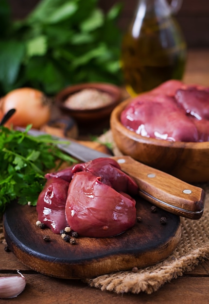 Foto gratuita hígado de pollo crudo para cocinar con cebollas y pimientos