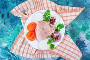 Foto gratuita hígado de pollo, hojas de lechuga y muslo de pollo en un plato sobre el paño de cocina