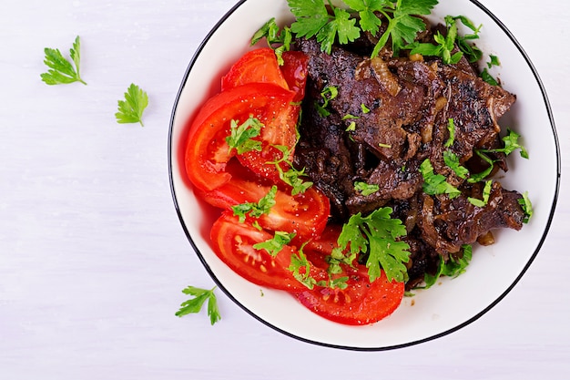 Hígado de res asado o a la parrilla con cebolla y ensalada de tomates