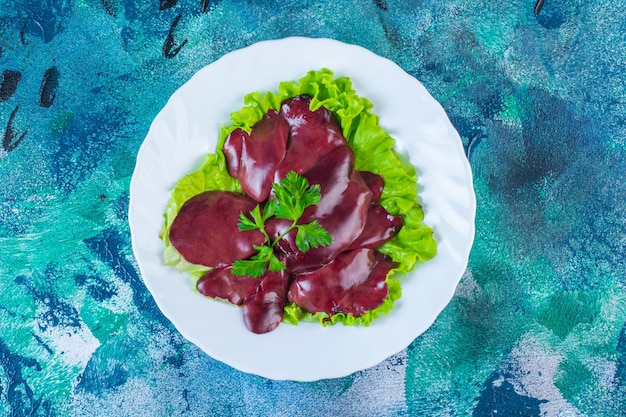 Foto gratuita hígados de pollo en una hoja de lechuga en la placa