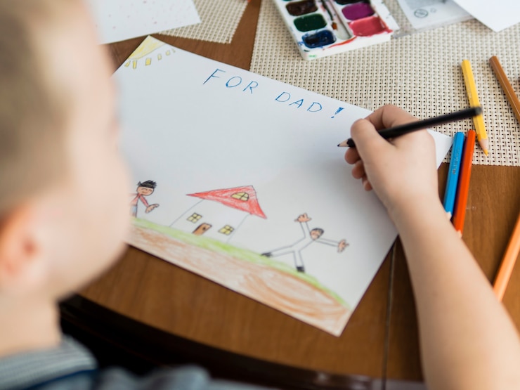Foto gratuito high view niño y dibujos para su padre