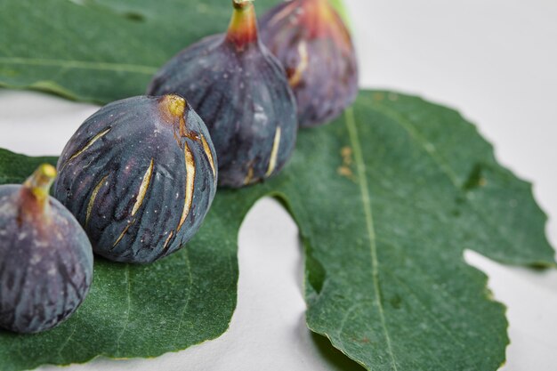 Higos morados con una hoja en blanco.