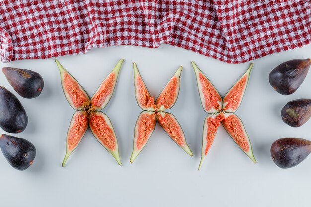 Higos con rodajas en blanco y papel de cocina, plano.