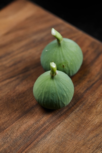 Foto gratuita higos verdes maduros en mesa de madera.