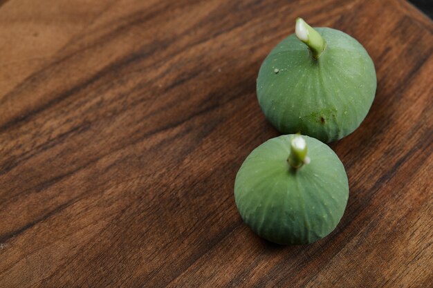 Higos verdes maduros en mesa de madera.