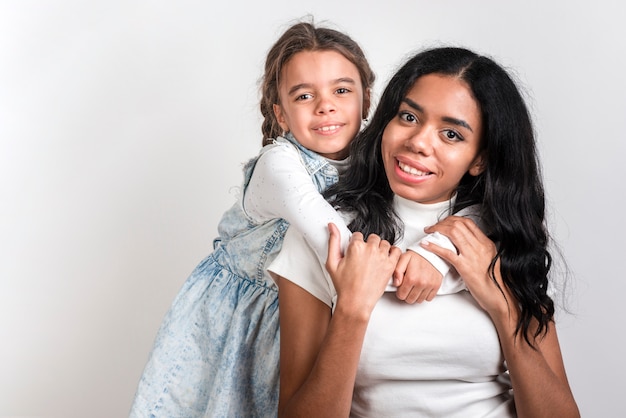 Hija abrazando a mamá con espacio de copia