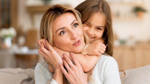 Hija abrazando a su madre en casa