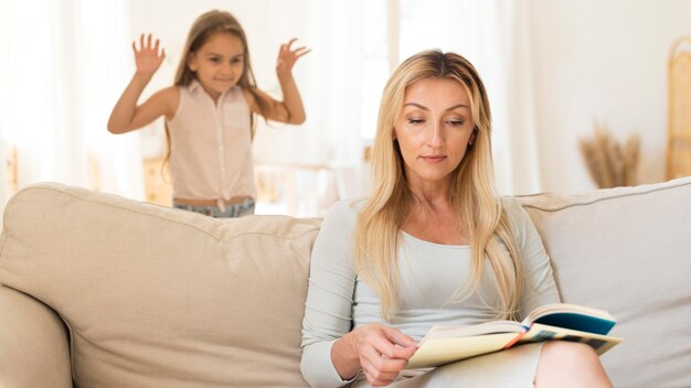 Hija acercándose sigilosamente a su madre en el sofá