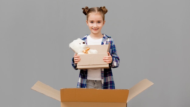 Foto gratuita hija ayudando con cajas de embalaje