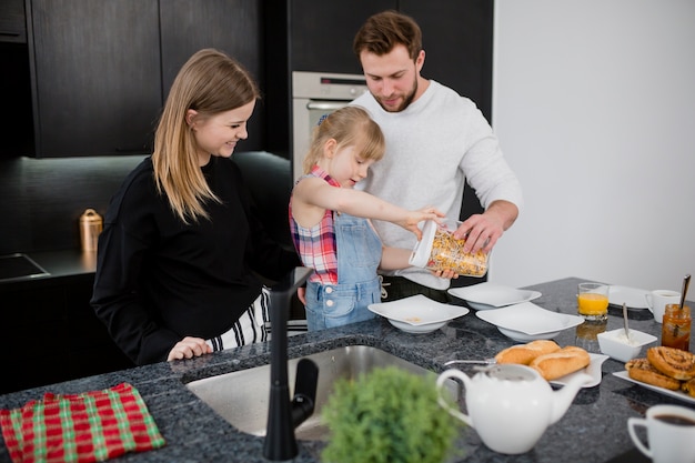 Hija ayudando a los padres a preparar el desayuno