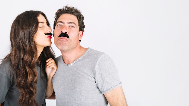 Hija con bigote besando padre