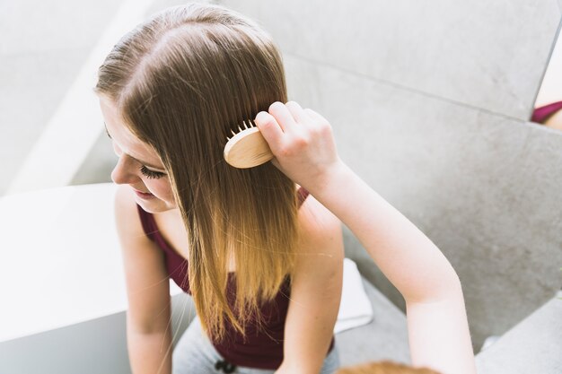 Hija de la cosecha peinando el pelo de la madre