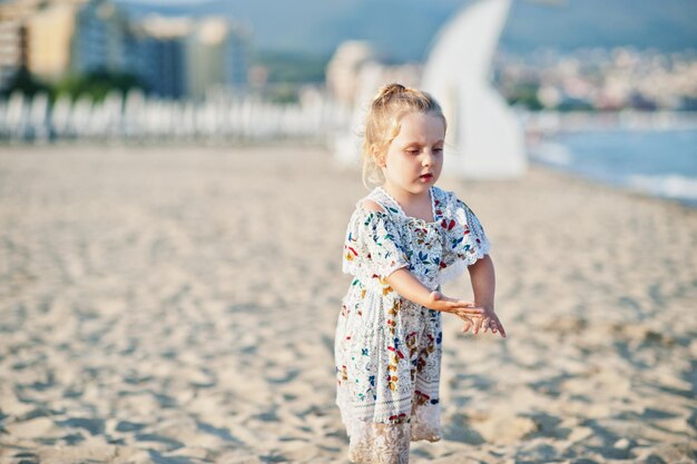Hija divirtiéndose en la playa Retrato de feliz linda niña pequeña de vacaciones