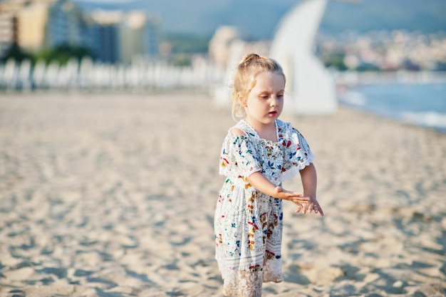 Hija divirtiéndose en la playa Retrato de feliz linda niña pequeña de vacaciones