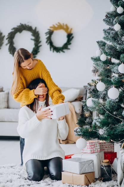 Hija haciendo presente sorpresa para madre en Navidad