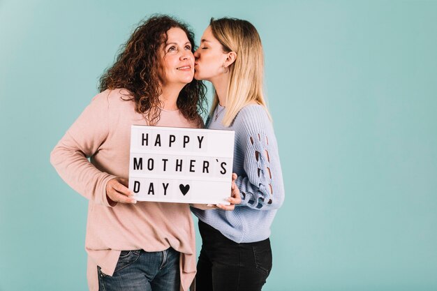 Hija joven, besar, mamá, en, día de la madre