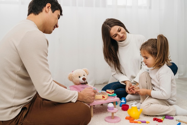 Hija jugando con los padres en casa