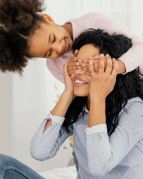 Hija jugando con su madre en casa