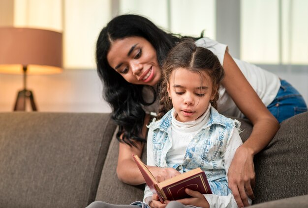 Hija leyendo con apoyo de mamá