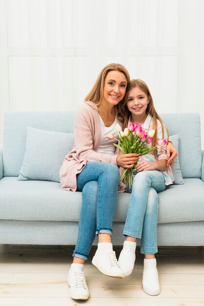 Hija y madre abrazando con flores