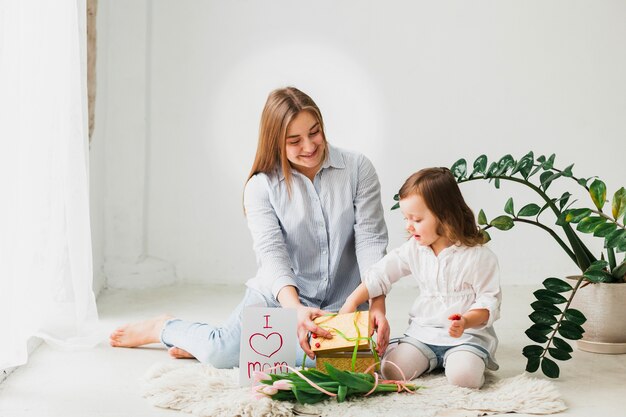 Hija y madre abriendo caja de regalo