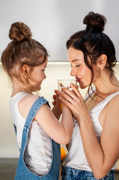 Hija y madre compartiendo jugo de naranja juntas