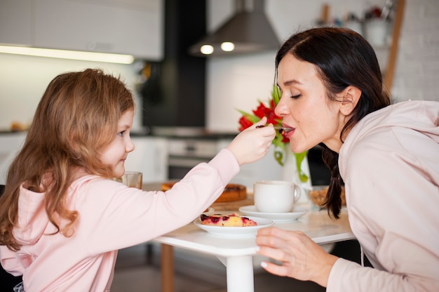 Hija y madre compartiendo postre juntas