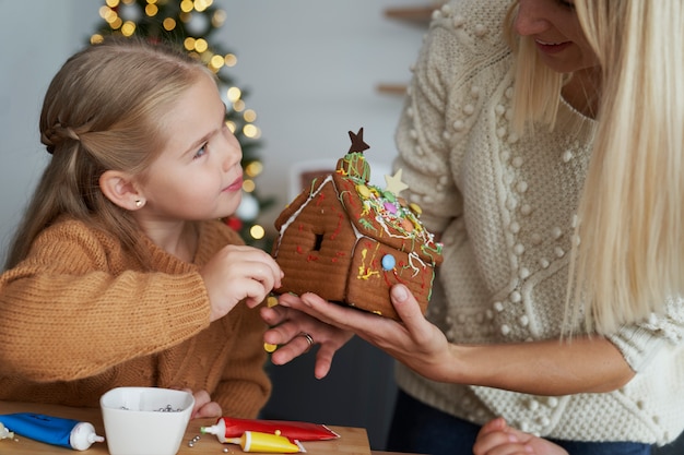 Hija y madre decorando la casa de pan de jengibre