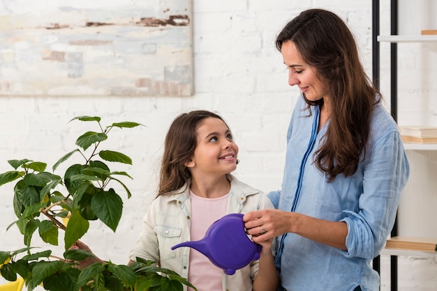Hija y madre regando una planta