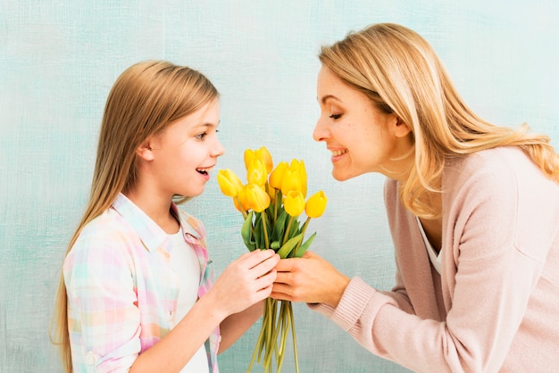 Hija y madre sosteniendo tulipanes