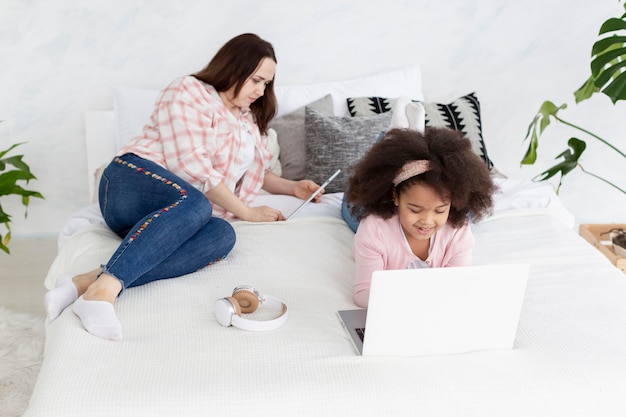 Hija y madre trabajando juntas desde casa