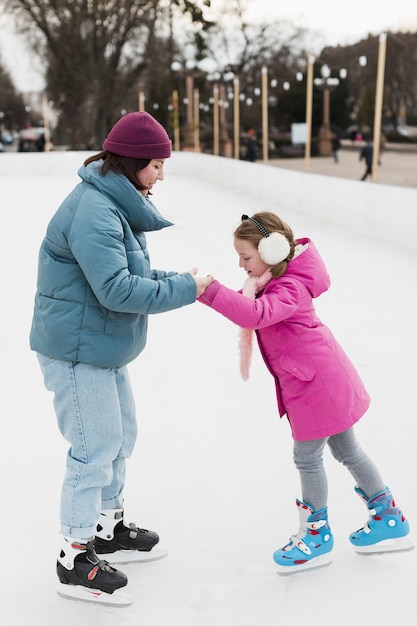 Foto gratuita hija y mamá patinar sobre hielo juntas