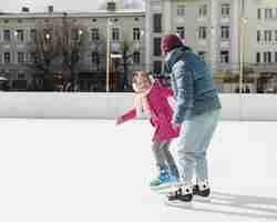 Foto gratuita hija y mamá patinar sobre hielo juntas