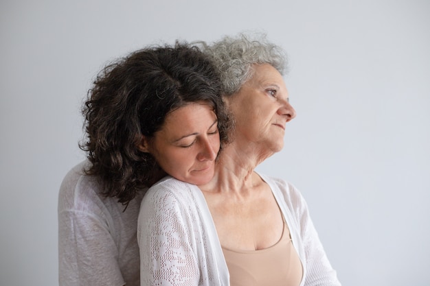 Hija de mediana edad abrazando a madre senior