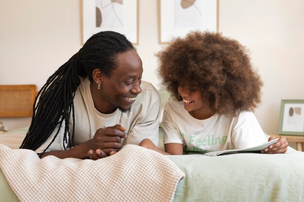 Hija y padre leyendo un libro juntos